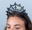Black glitter spiderweb headband with a gold spider decoration.
