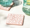 Set of two ceramic drinks coasters featuring an elegant embossed pattern, reminiscent of traditional tile designs.
