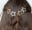 Silver and gold glitter star hair clips in a set of four.