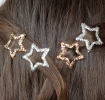 Silver and gold glitter star hair clips in a set of four.