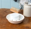 Round two-part soap dish with drainage holes.
