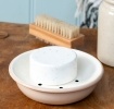 Round two-part soap dish with drainage holes.