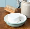 Round two-part soap dish with drainage holes in sage green.