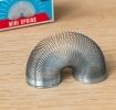 Mini metal spring toy displayed in a curved shape beside blue Wild Bear branded retail packaging.