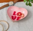 Heart-shaped pink trinket dish with red “LOVE” text