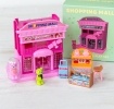 Pink toy shopping mall play set with miniature storefront and packaging box