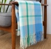 Blue, green and white check blanket displayed over a wooden armchair