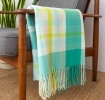 Green, white, lime green and tea check blanket displayed over a wooden armchair