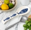 White ceramic spoon rest with blue fish design.