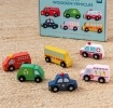 Set of six wooden toy vehicles with storage box, including bus, ambulance and fire engine