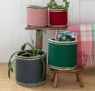 Set of four nested woven jute baskets in grey, green, pink and red