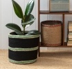 Set of two round jute storage baskets in natural and black.