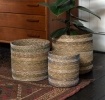 Set of three round seagrass baskets in assorted sizes.