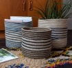 Set of three round jute striped jute baskets in assorted sizes.