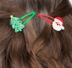 Christmas hair clips featuring Santa faces and glitter Christmas trees