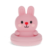 Pink silicone bunny bath toy with upright ears and simple face, in round base