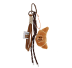 Plush croissant bag charm with brown cord strap and metal clip attachment