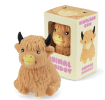 Highland cow squishy toy with textured fur and black horns, shown beside matching display box.