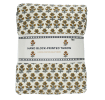 Hand block-printed throw with yellow floral pattern, folded in packaging.