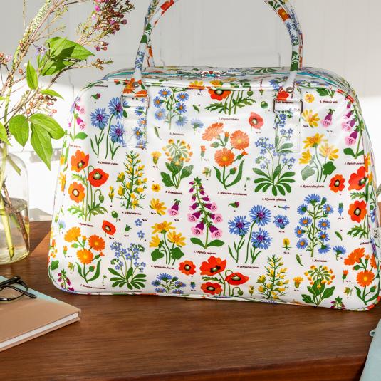 White oilcloth weekend bag with images of wild flowers