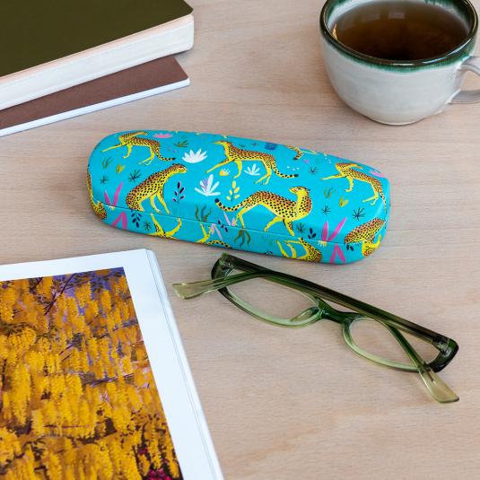 Turquoise hardshell glasses case with print of cheetahs on table