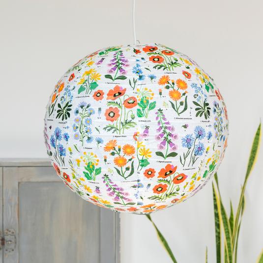 White paper lampshade with wild flower decoration installed in room