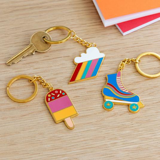 Roller skate, ice lolly and cloud burst keyring collection on table