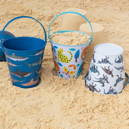 Tin bucket collection on beach with Wild Wonders design containing sand