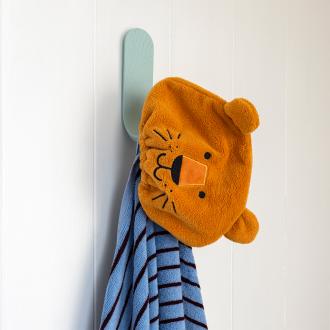 Lion-themed orange bath hat with ears hanging on a wall