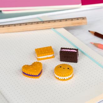 Four biscuit-shaped erasers in different styles and colours, placed on a notebook 
