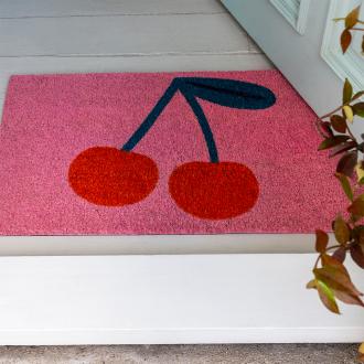 doormat featuring red cherry print in a pink background