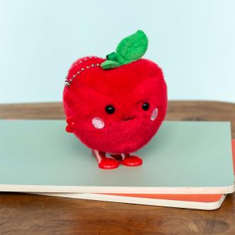 Red apple-shaped plush wind-up toy with a smiling face and a green leave on top