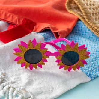 pink flower-shaped funglasses with gold glittery accents and dark round lenses.