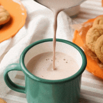 Enamelware mug with glossy dark green finish and black rim. 