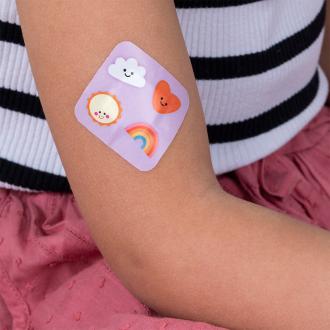 Plaster applied to a kid's arm with a kawaii sunshine-themed design.