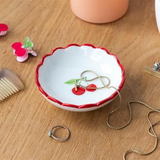 Round ceramic trinket dish with scalloped red edge and cherry design in the center.