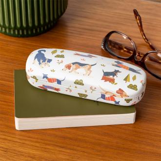 glasses case with playful dog illustrations resting on a notebook beside a pair of glasses.