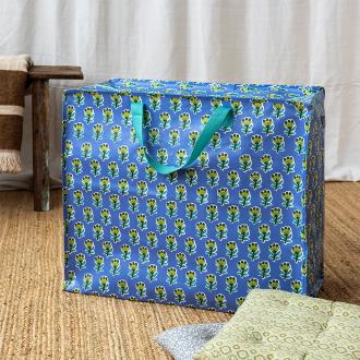 Large blue storage bag with green floral pattern and turquoise handles.