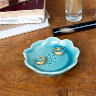Ceramic trinket dish with a scalloped edge and a floral design in the centre.
