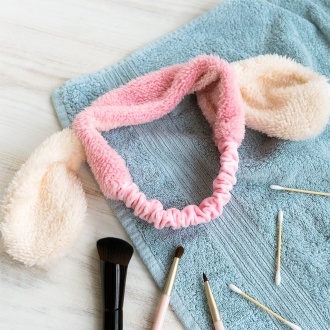 Pink plush fabric hairband with soft white bunny ears.