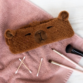 Soft and cosy headband, featuring the friendly face of a capybara. 