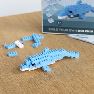 Completed dolphin brick model displayed beside its packaging box.