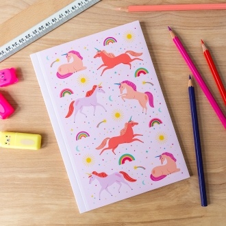 Pink notebook with colourful unicorns, rainbows, stars, and suns on the cover.