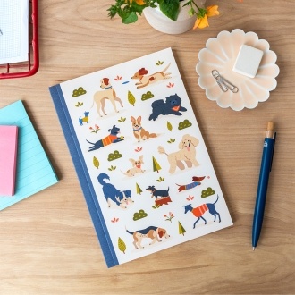 Notebook with illustrated dogs in a park scene on the cover.
