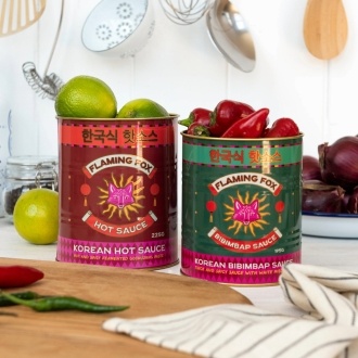 Two Flaming Fox Korean sauce storage tins, one red hot sauce and one green bibimbap design
