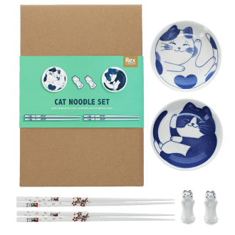 Two cat-themed dipping bowls, two pairs of chopsticks, and two cat-shaped rests beside a brown box.