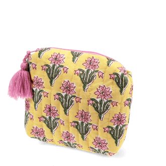 Yellow quilted cosmetic bag with a pink and green floral print and a pink tassel on the zip.