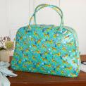 Turquoise oilcloth weekend bag with print of cheetahs