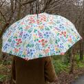 White umbrella with wild flower pattern used by person outside
