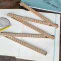 Wooden folding ruler partially unfolded on exercise book